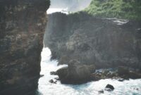 Majestic ocean view with rocky cliffs and waves crashing on the coast of Bali, Indonesia.