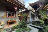 Charming Balinese courtyard showcasing intricate carvings, lush greenery, and cultural decor.