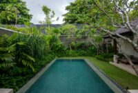 Luxurious villa pool surrounded by lush tropical greenery in Bali, Indonesia.