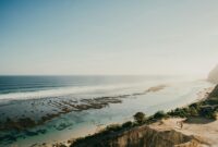 villa tranquilla nusa lembongan A stunning aerial view of Bali's coastline with clear blue waters and rugged cliffs.