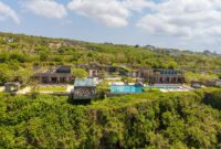 bali villa construction Aerial view of a luxurious villa with an infinity pool on a cliffside in Bali, Indonesia.