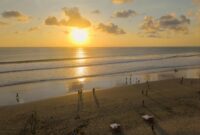 the kanjeng seminyak Beautiful sunset on Seminyak Beach, Bali with people enjoying the view and golden sands.